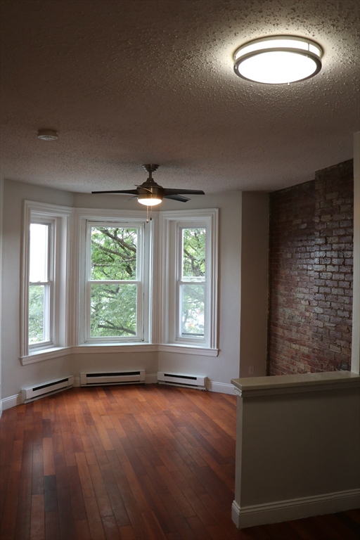 320 Warren Street, Unit 2 Boston, MA 02119 - Photo 4 of 22 an empty room with wooden floor and windows
