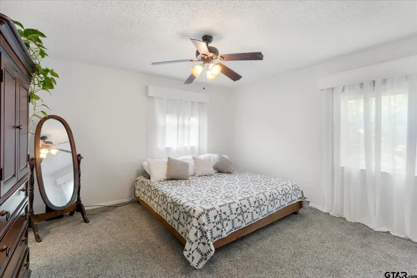 a bedroom with a bed a window and a chandelier