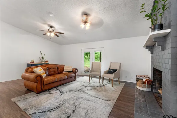 a living room with furniture a fireplace and a chandelier
