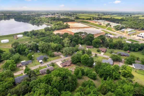 an aerial view of residential houses with outdoor space and lake view