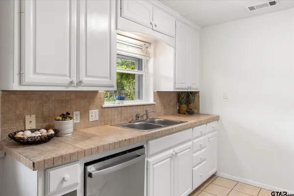a kitchen with a sink cabinets and window
