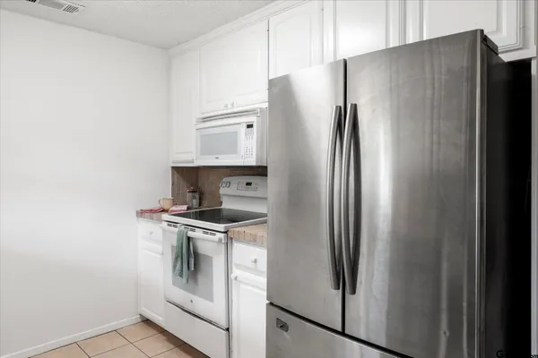 a metallic refrigerator freezer sitting in a kitchen