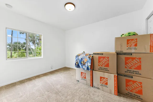 a spacious bedroom with a bed and wooden floor