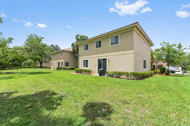 a front view of a house with a yard and a garden