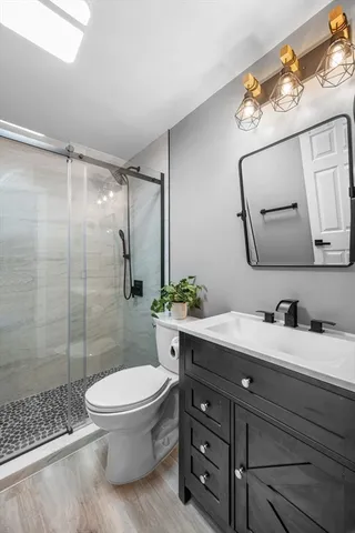 a bathroom with a toilet a sink and glass door