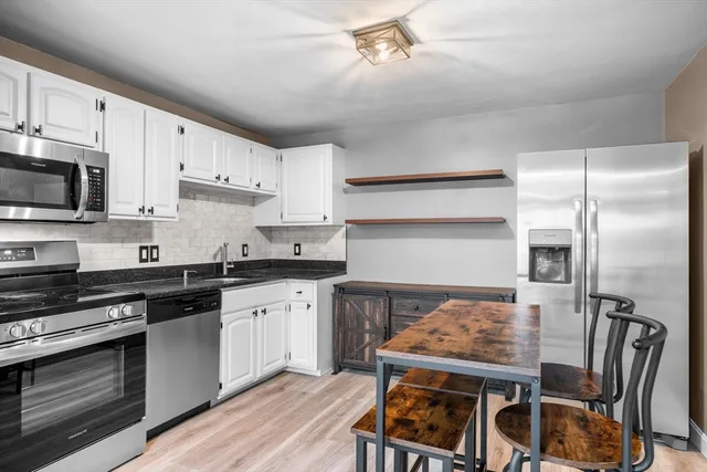 a kitchen with a table chairs microwave and cabinets
