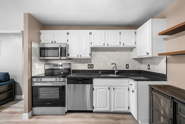 a kitchen with granite countertop a sink and steel appliances