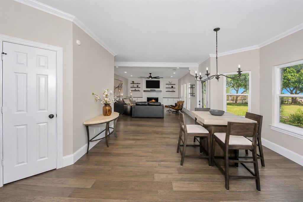 3817 Ganzer Road West Denton, TX 76207 - Photo 18 of 40 This angle shows how the breakfast area connects seamlessly to the living room, keeping the whole space bright and open. The windows pull in those backyard views, and the door to the left leads to a large walk-in pantry, making everyday cooking and storage easy. It’s a comfortable, connected spot that sits right at the heart of the home.