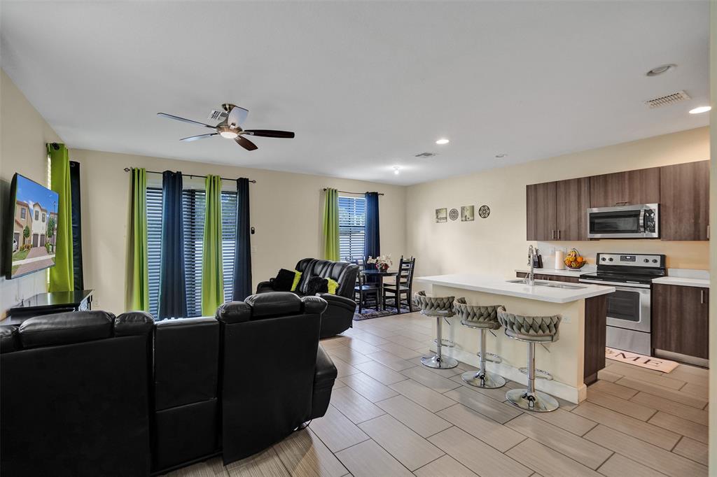 4875 Northwest 55th Place Tamarac, FL 33319 - Photo 13 of 44 a living room with furniture a flat screen tv and kitchen view