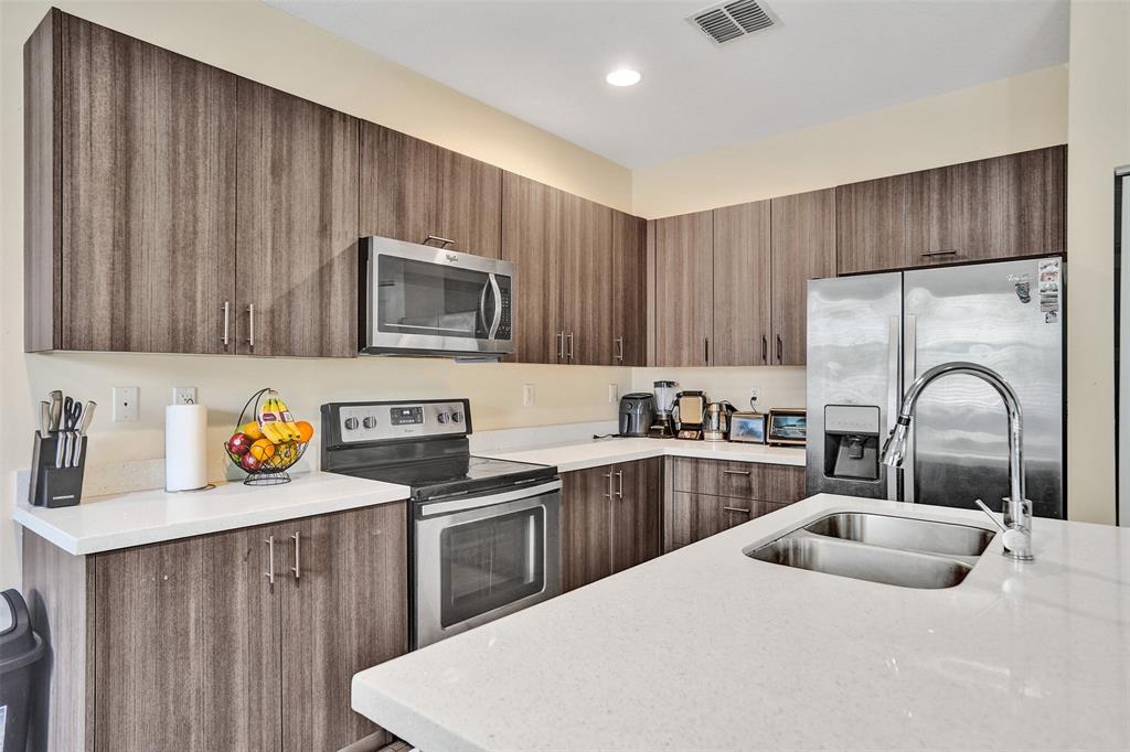 4875 Northwest 55th Place Tamarac, FL 33319 - Photo 17 of 44 a kitchen with a sink a stove and cabinets