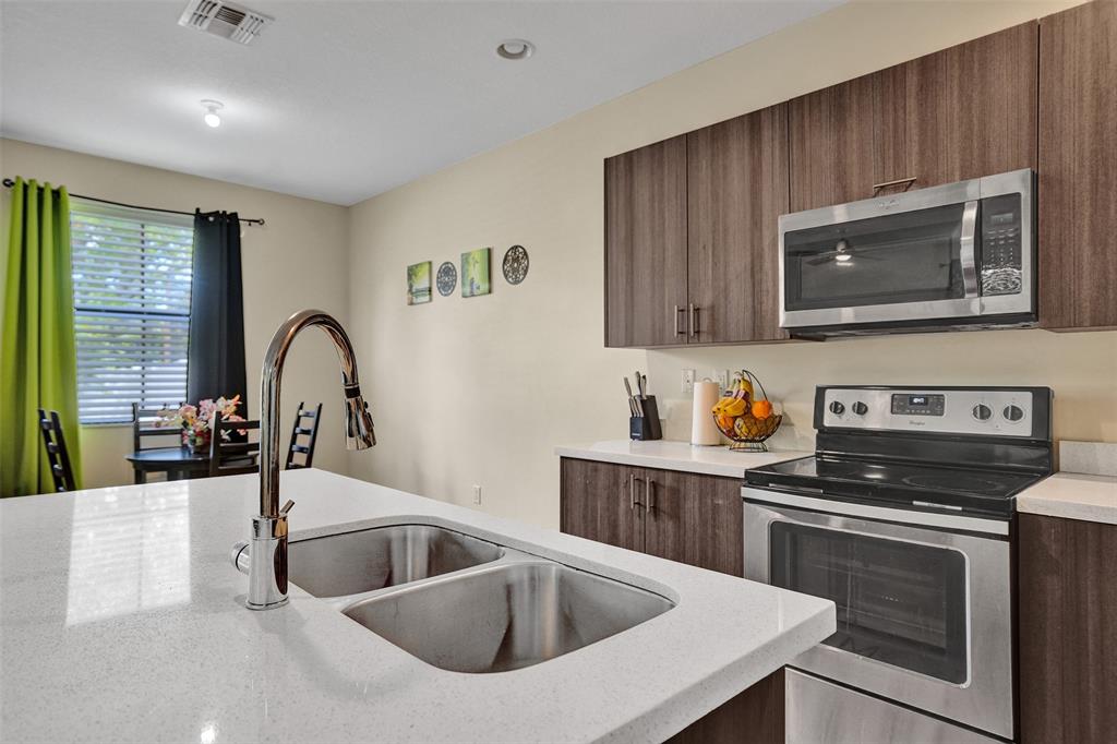 4875 Northwest 55th Place Tamarac, FL 33319 - Photo 19 of 44 a kitchen with a stove a sink and a microwave