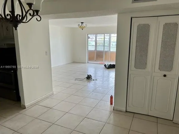 a view of an entryway and a livingroom with wooden floor