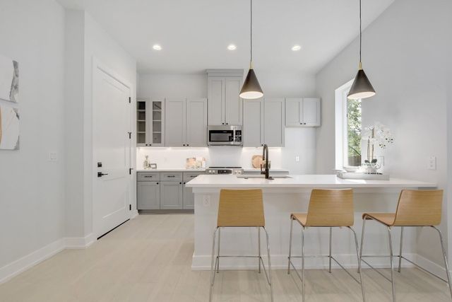 a kitchen with kitchen island wooden cabinets and white appliances