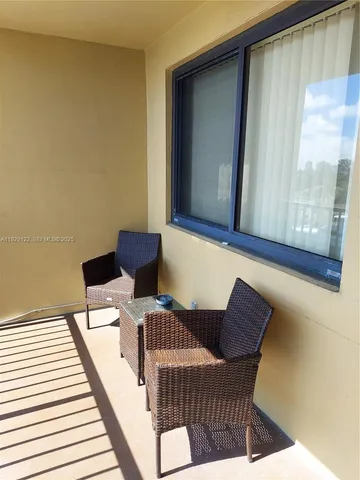 a view of a chairs and table in the balcony