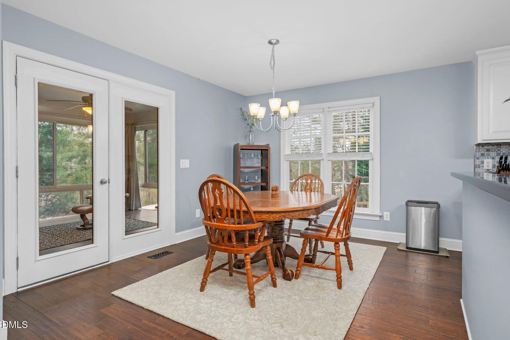 259 Sacred Fire Road Louisburg, NC 27549 - Photo 12 of 35 a dining room with furniture a chandelier and wooden floor