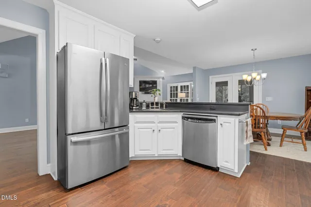 a kitchen with granite countertop white cabinets and appliances