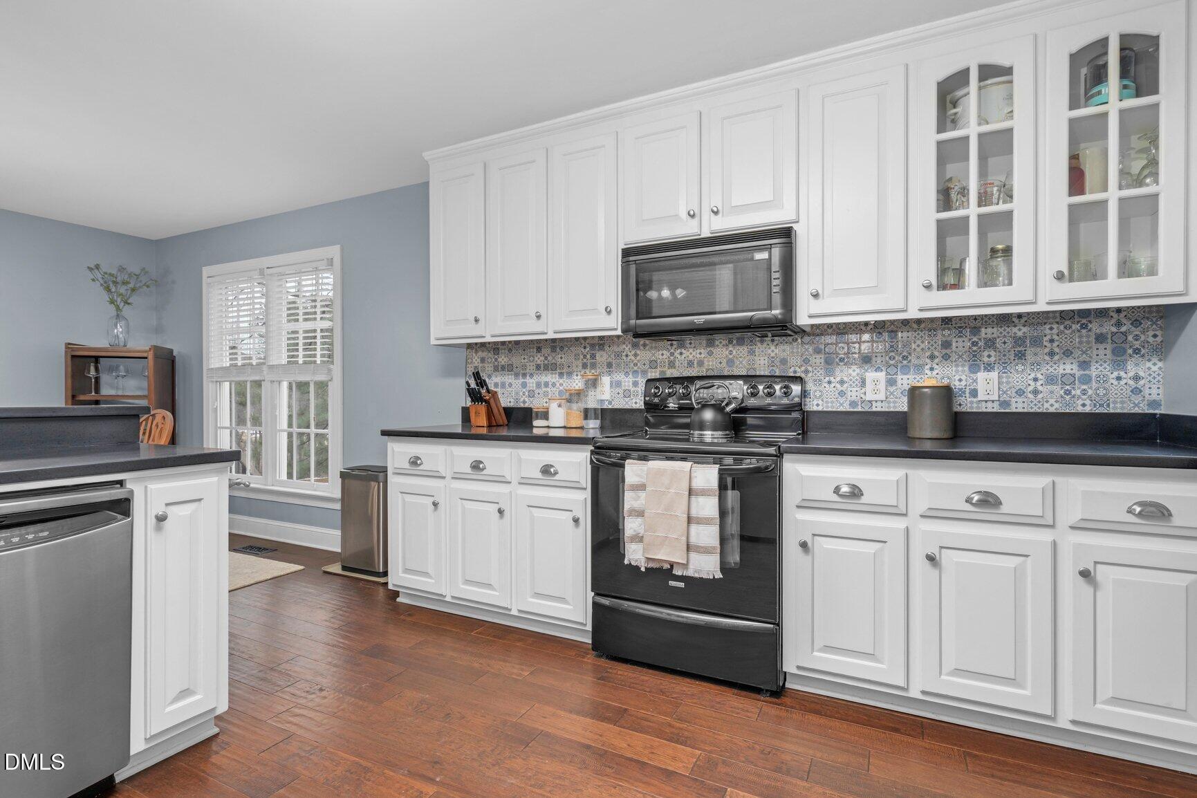 259 Sacred Fire Road Louisburg, NC 27549 - Photo 16 of 35 a kitchen with granite countertop white cabinets and appliances