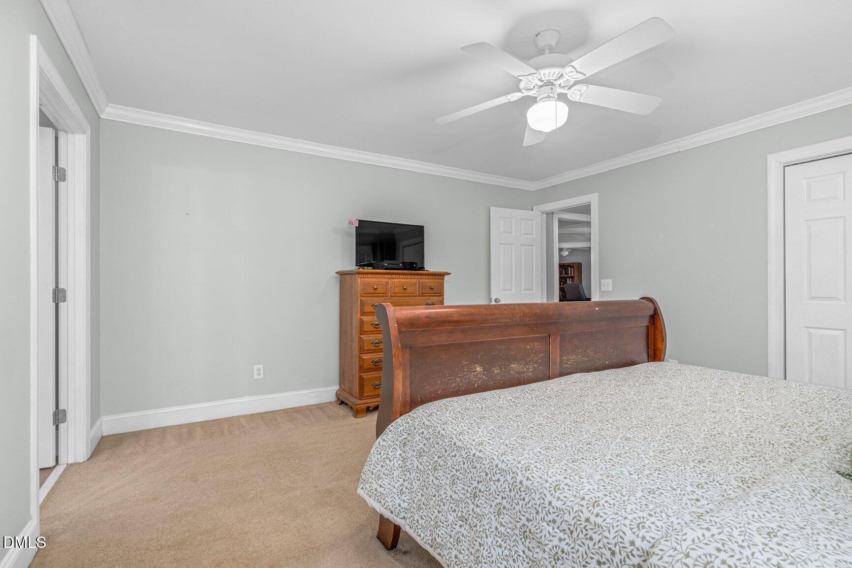 259 Sacred Fire Road Louisburg, NC 27549 - Photo 25 of 35 a bedroom with a bed and a chandelier