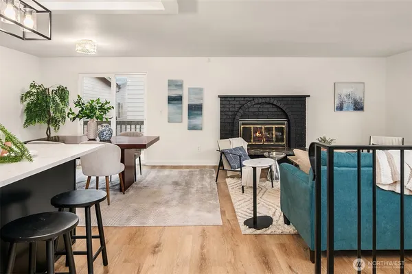 a living room with furniture a fireplace and a potted plant