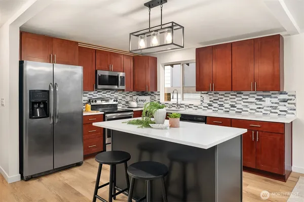 a kitchen with stainless steel appliances a dining table and chairs