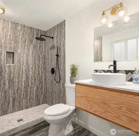 a bathroom with a sink a toilet a mirror and shower