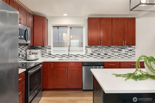 a kitchen with stainless steel appliances granite countertop a sink stove and cabinets