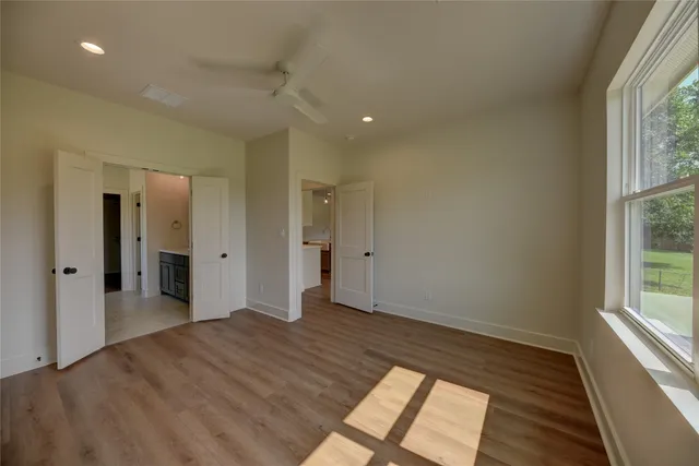 a view of a big room with wooden floor and windows
