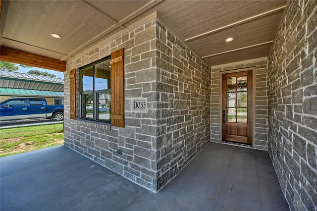 a view of a balcony with door and wooden floor
