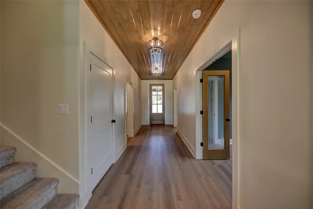 a view of a hallway with wooden floor and staircase