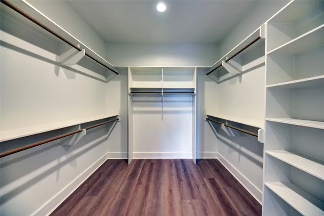 a view of walk in closet with wooden floor