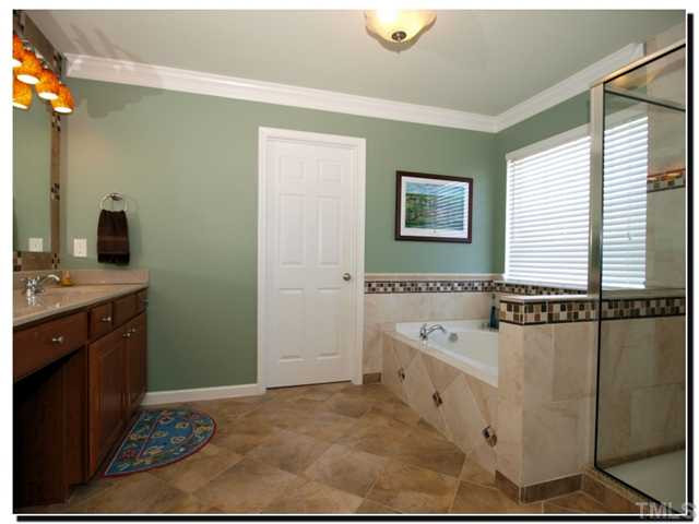 10702 Friendly Neighbor Lane Raleigh, NC 27614 - Photo 13 of 25 Large master bath with natural stone tile with inlays. Separate tub / shower, his/hers closet, large vanity with double sinks, and dressing area. Master Bath/Spa