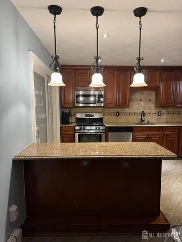 a kitchen with stainless steel appliances granite countertop a sink a stove and a wooden floors