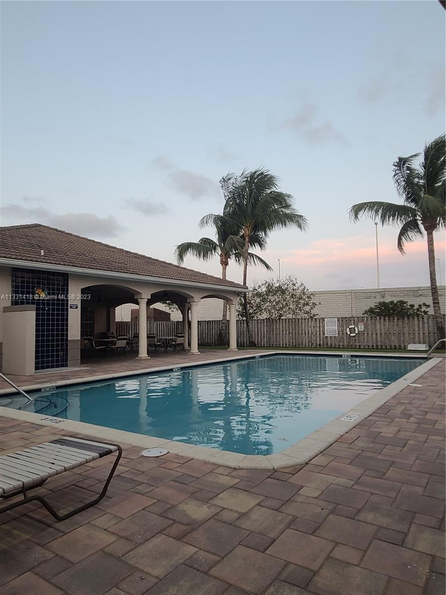 8331 Southwest 124th Avenue, Unit 10414 Miami, FL 33183 - Photo 11 of 12 a view of a house with swimming pool and a yard