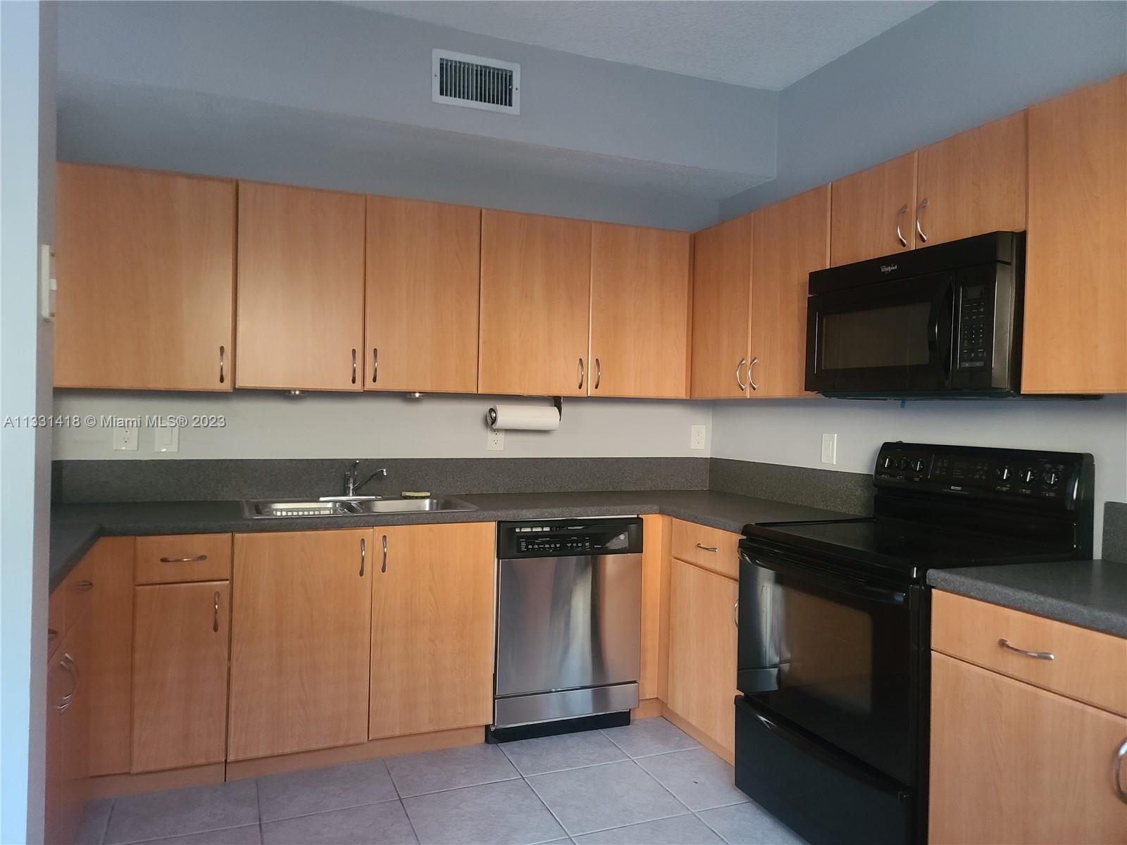 8331 Southwest 124th Avenue, Unit 10414 Miami, FL 33183 - Photo 5 of 12 a kitchen with stainless steel appliances granite countertop a stove and a microwave