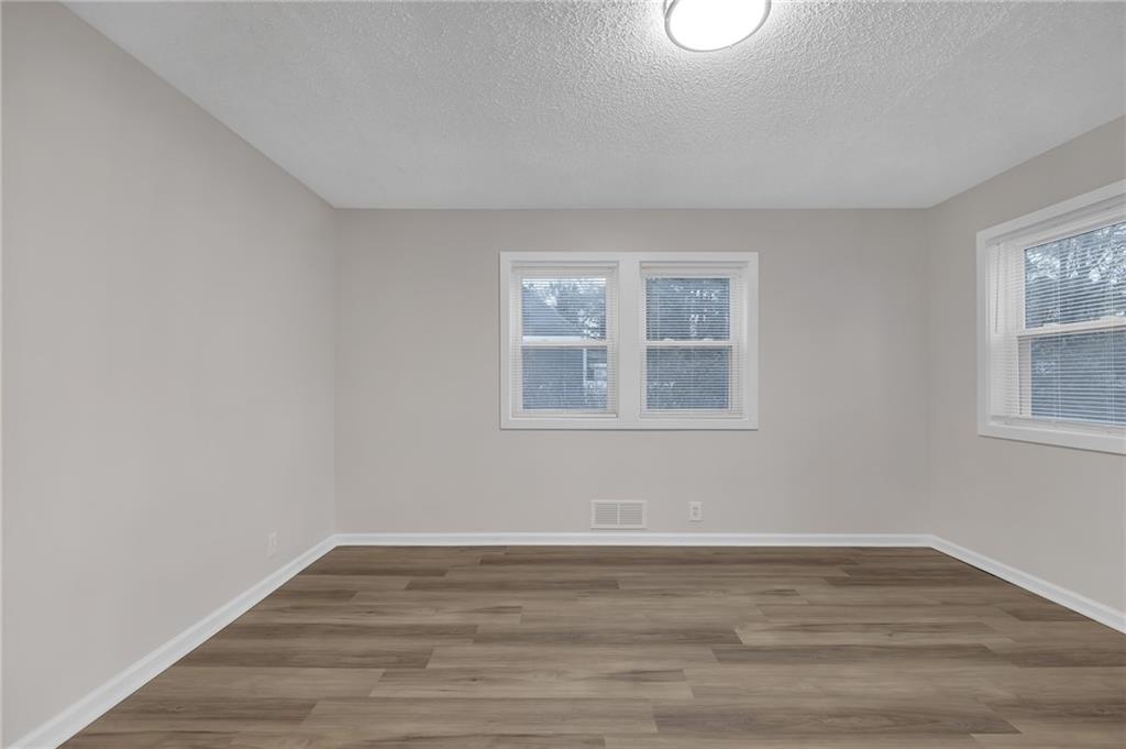 1683 Candler Road Decatur, GA 30032 - Photo 13 of 26 a view of an empty room with wooden floor and a window