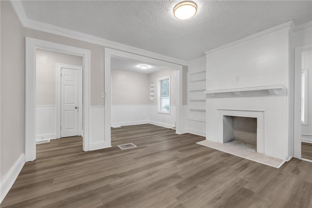 1683 Candler Road Decatur, GA 30032 - Photo 6 of 26 an empty room with wooden floor and fireplace