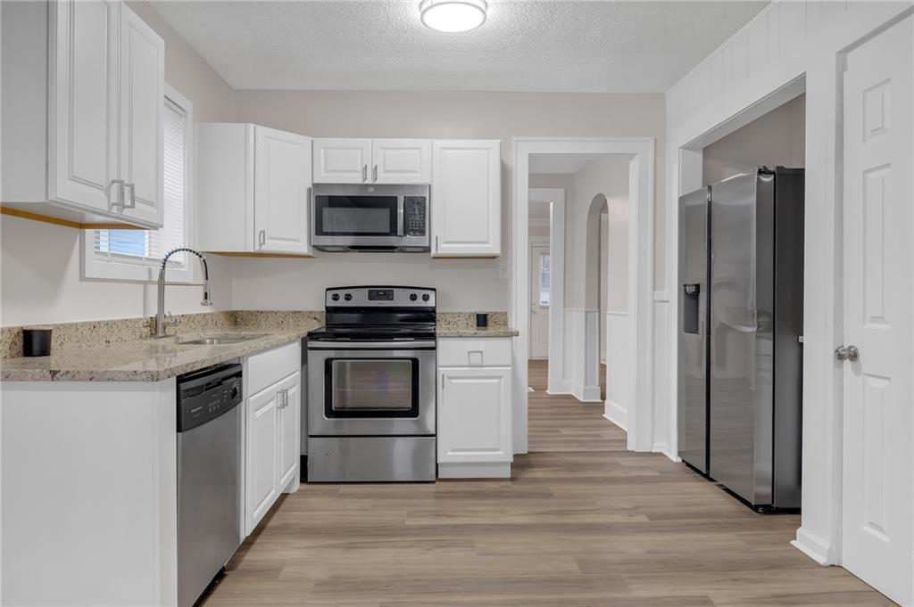 1683 Candler Road Decatur, GA 30032 - Photo 8 of 26 a kitchen with stainless steel appliances granite countertop a stove a sink and a refrigerator