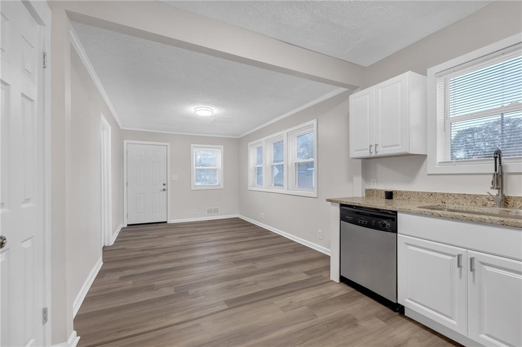 1683 Candler Road Decatur, GA 30032 - Photo 10 of 26 a kitchen with granite countertop white cabinets and white appliances