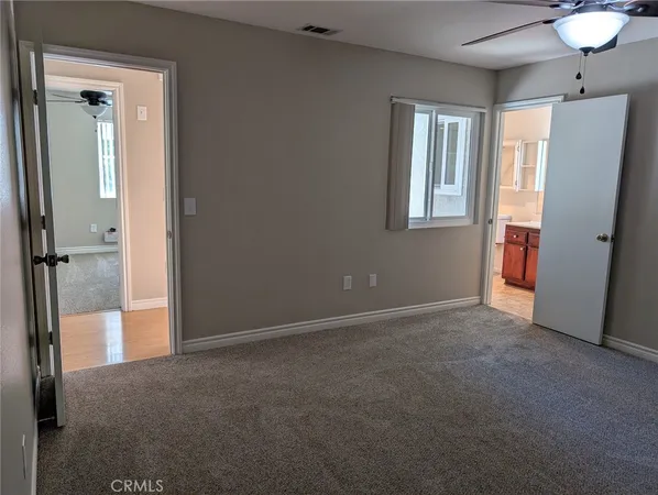 an empty room with windows and cabinet
