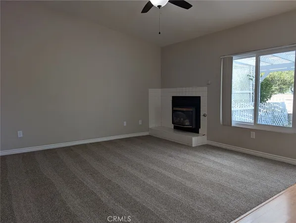a view of an empty room with a window and fireplace