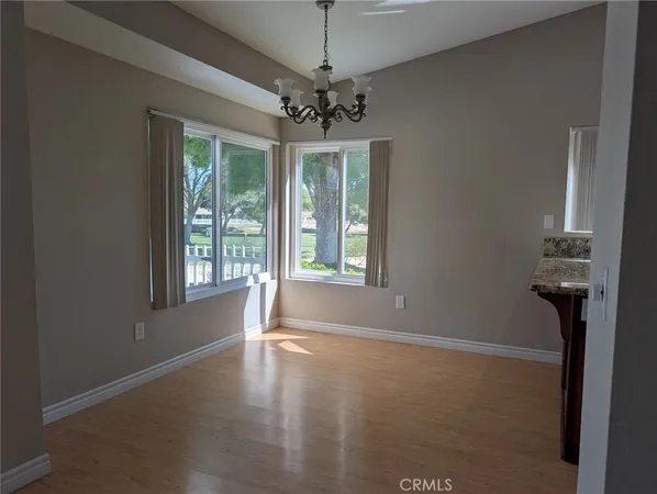 a view of a livingroom with a chandelier fan and windows