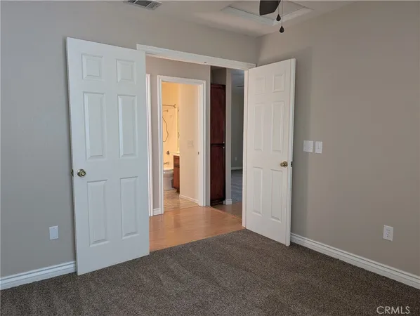 an empty room with closet and a bathroom