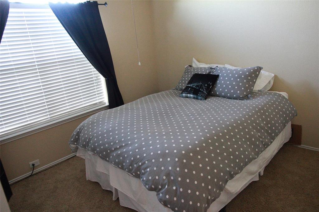13153 Fencerow Road Fort Worth, TX 76244 - Photo 9 of 16 Carpeted bedroom featuring a window with horizontal blinds and dark drapery, light-toned walls, and white baseboards