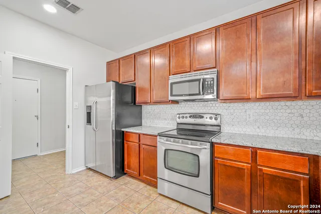 a kitchen with stainless steel appliances granite countertop a refrigerator stove and sink