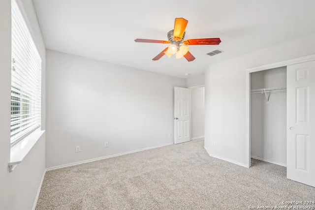 a view of a livingroom with a ceiling fan and window