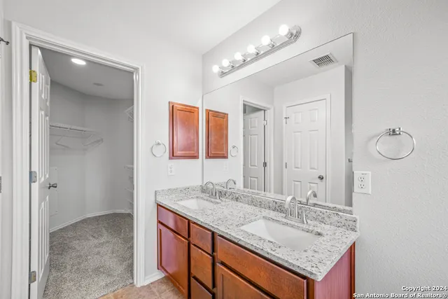 a bathroom with a granite countertop sink and a mirror