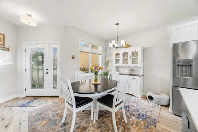 a dining room with furniture a chandelier and wooden floor