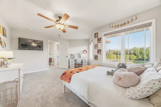 a spacious bedroom with a bed and a flat screen tv