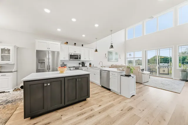 a kitchen with a sink stove cabinets and wooden floor