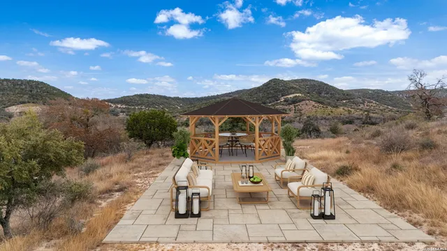 a view of a terrace with a table and chairs under an umbrella
